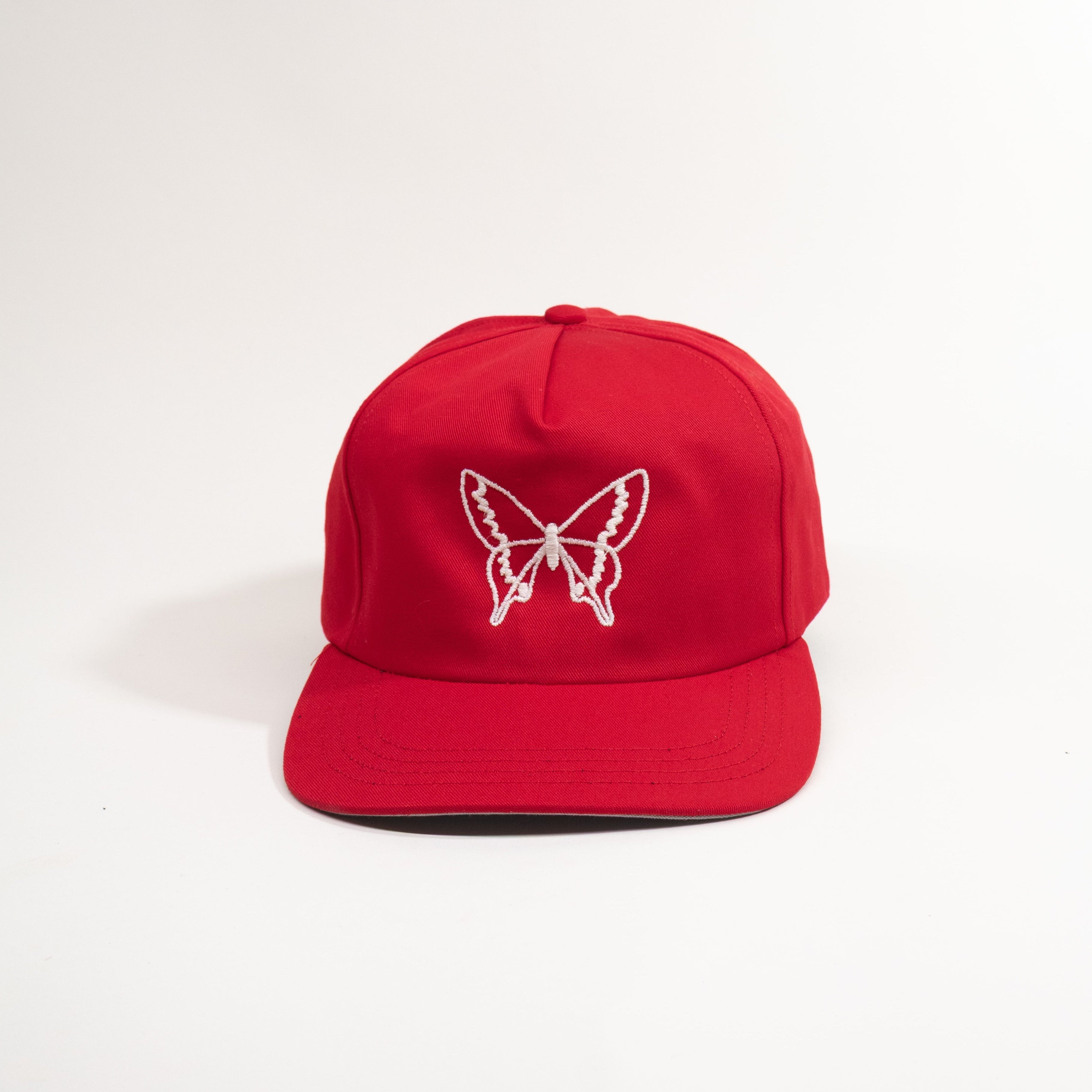 Red cap with a white butterfly design on a white background