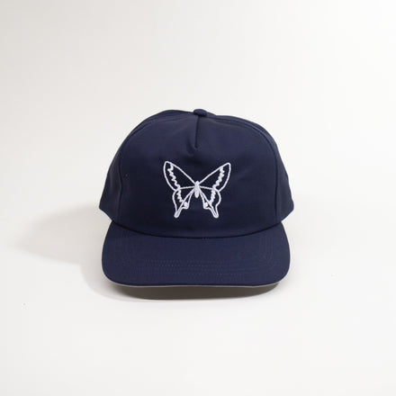 Navy blue cap with a white butterfly design on a white background