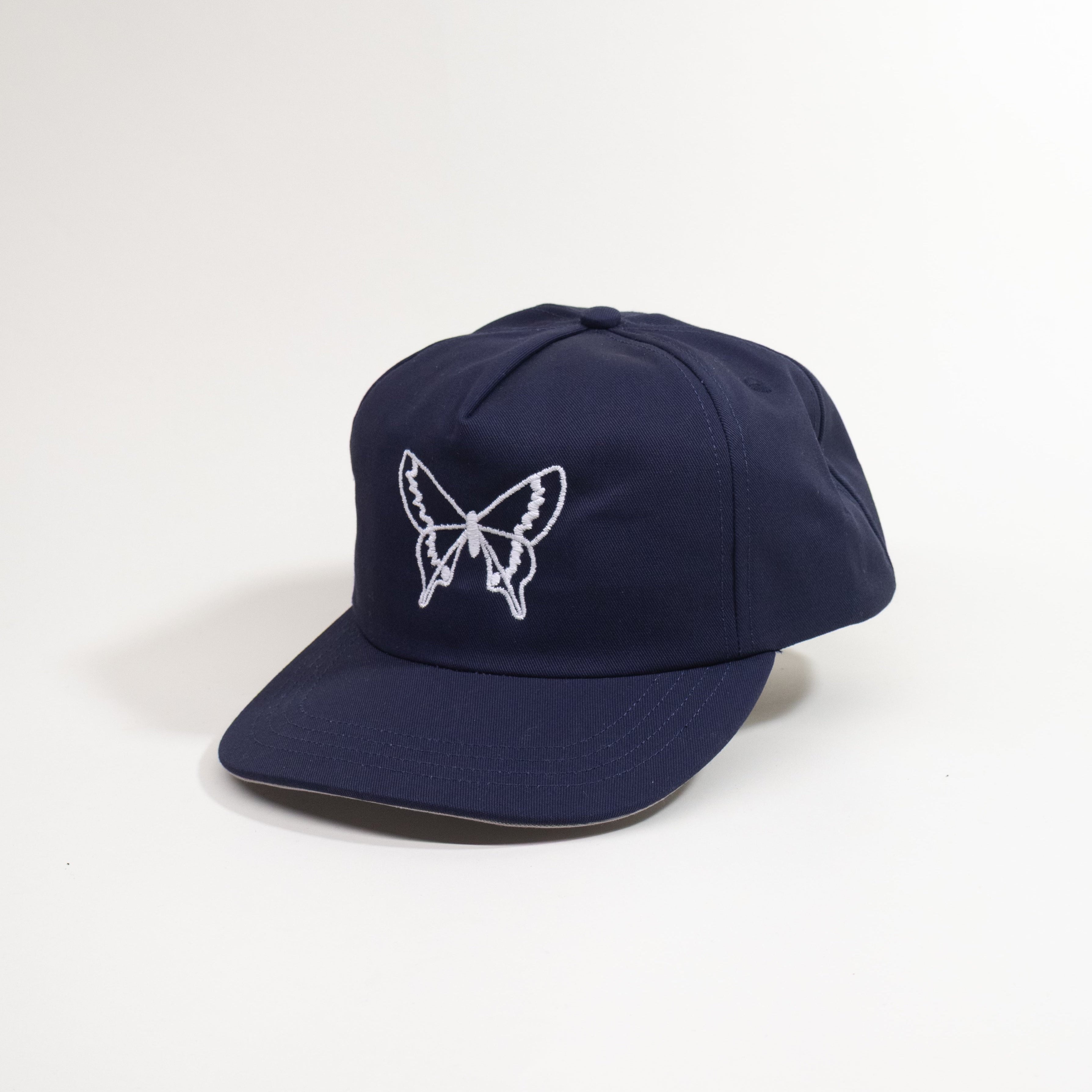 Navy blue cap with a white butterfly emblem on a white background