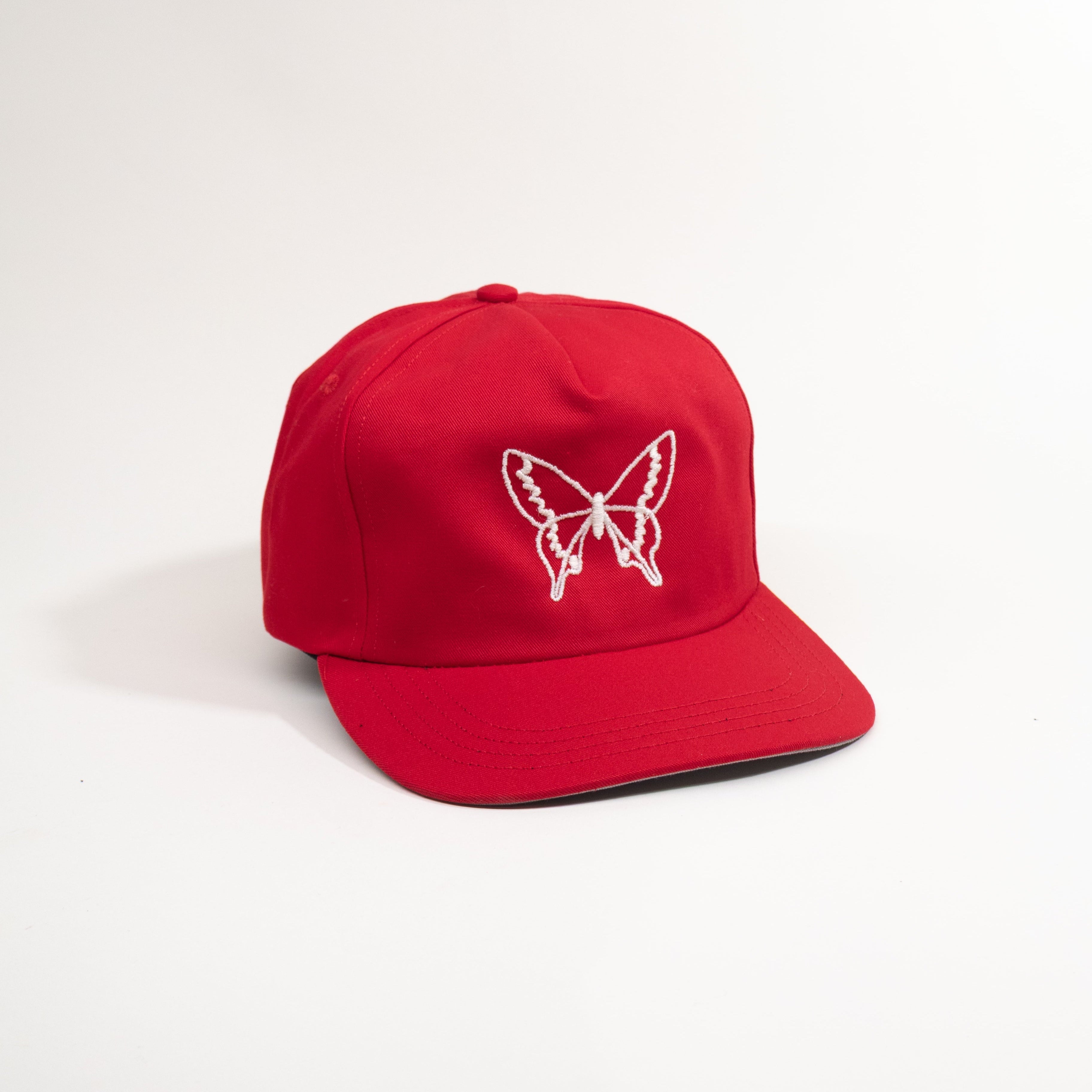 Red cap with a white butterfly design on a light white background